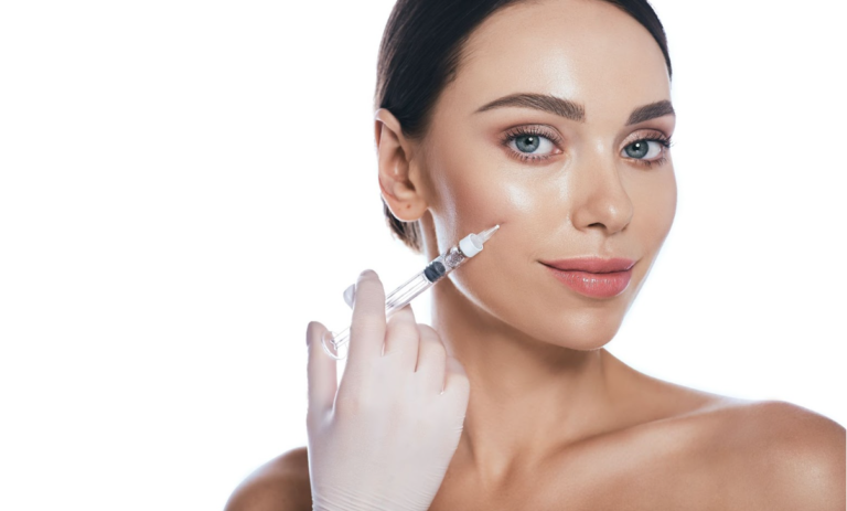 Close-up of a woman with glowing skin holding a dermal filler syringe near her cheek, symbolizing contouring and volume enhancement, at EstrogenicA clinic.